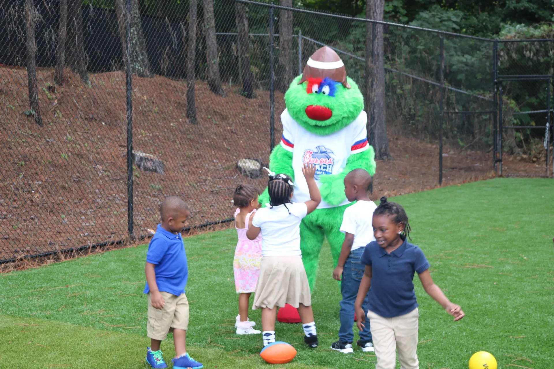 Chik Fil A Peach Bowl mascot playing with children.