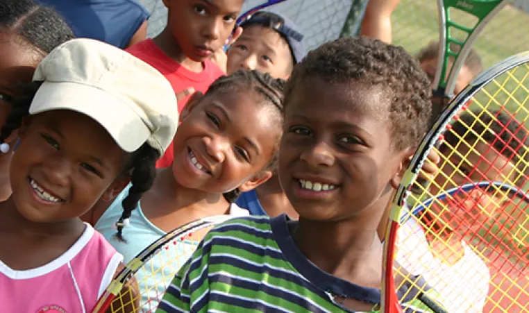 Smiling kids with tennis rackets