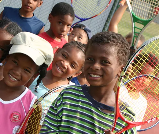 Smiling kids with tennis rackets