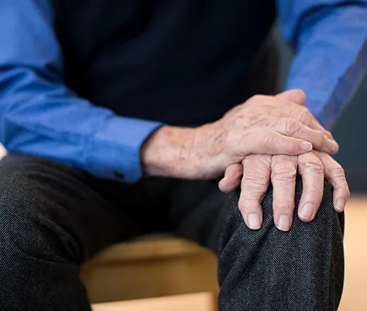 Man with Parkinsons holding his hand