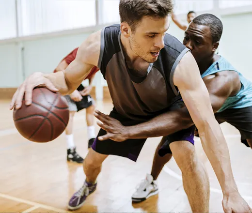 Men playing basketball in gym